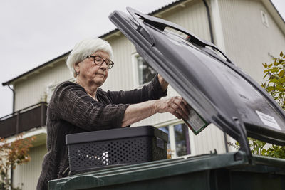 Woman putting rubbish into bin