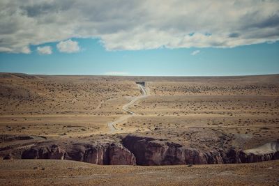 View of desert against cloudy sky