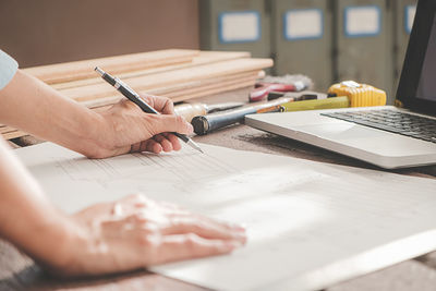 Midsection of man working on table