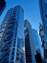 Low angle view of modern buildings against clear blue sky