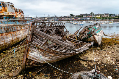 Fishing boats moored at shore against sky