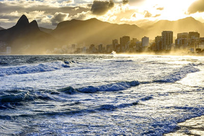 City by sea against sky during sunset