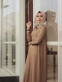 Woman looking through window at store