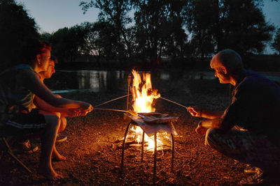 People sitting by bonfire