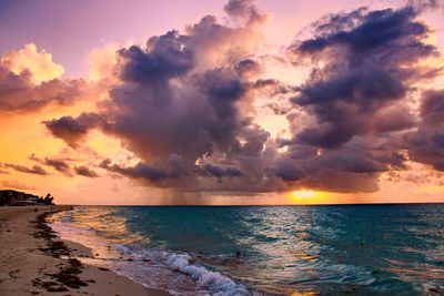 Scenic view of sea against dramatic sky during sunset