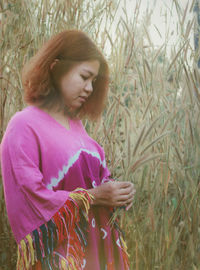 Young woman standing against plants