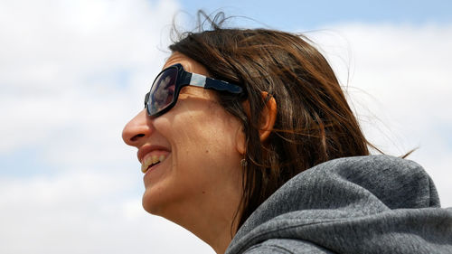 Low angle view of woman wearing sunglasses against sky