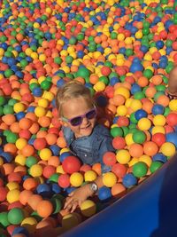 High angle view of girl wearing sunglasses playing in ball pool