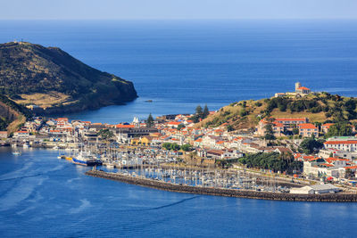 High angle view of townscape by sea against sky