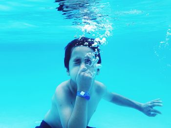 Shirtless boy swimming in pool