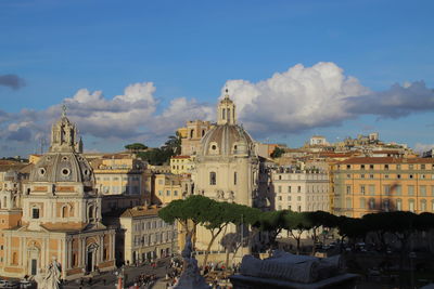 Buildings in city against cloudy sky
