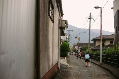 People walking on footpath amidst buildings in city