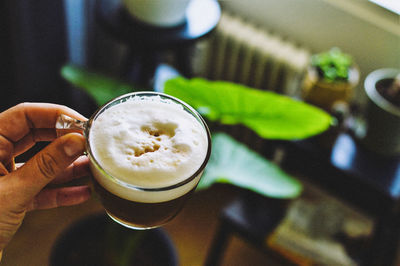 High angle view of hand holding coffee cup