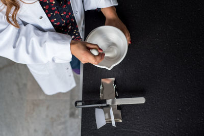 Midsection of female scientist preparing medicine in laboratory