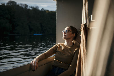 Woman wearing sunglasses sitting on boat deck
