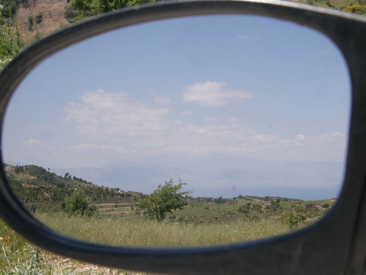 REFLECTION OF TREES ON SIDE-VIEW MIRROR OF CAR