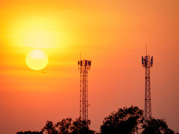 Silhouette of tower against orange sky