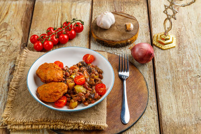 Cod cutlets with stewed potatoes and vegetables on a plate with ingredients. horizontal photo