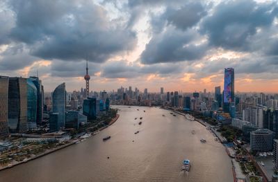 Panoramic view of buildings in city against cloudy sky