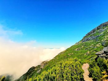 Scenic view of mountains against blue sky