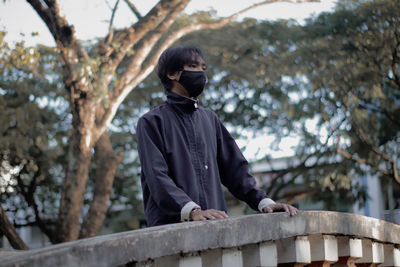 Low angle view of man standing against trees