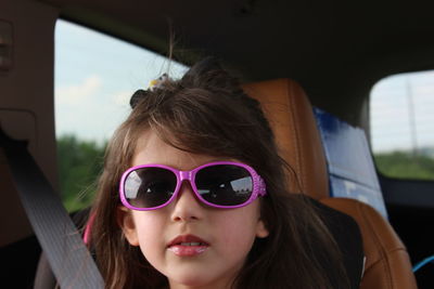 Close-up portrait of girl wearing sunglasses while traveling in car