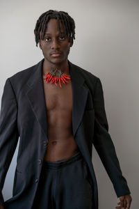 Portrait of young man standing against white background