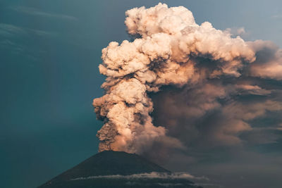 Smoke emitting from volcanic mountain against sky