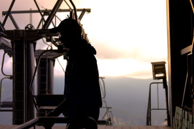 Side view of silhouette woman standing against sky during sunset