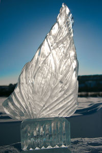 Close-up of ice on table against clear blue sky