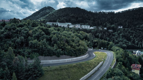 High angle view of road amidst trees in forest against sky