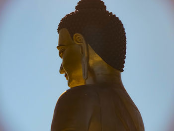 Low angle view of buddha statue against clear sky