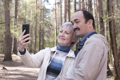 Portrait of man photographing with mobile phone