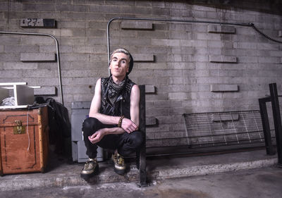 Young man crouching at parking garage