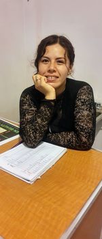 Portrait of a young woman sitting on table