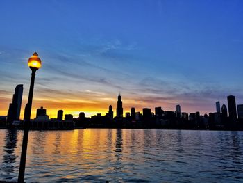 Silhouette buildings against sky at dusk
