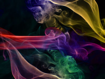 Close-up of colorful abstract smoke pattern against black background
