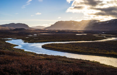 Scenic view of river and mountains against sky