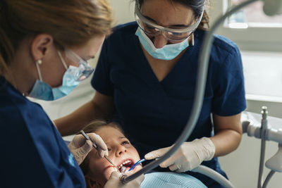 Female dentists examining girl