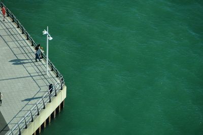 High angle view of people by railing over sea