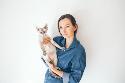 Portrait of smiling young woman holding cat