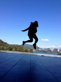 Full length of woman jumping in mid-air