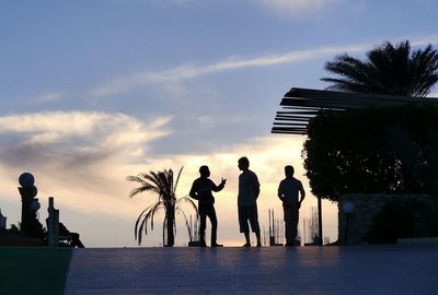 Silhouette people on landscape at sunset