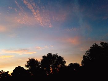 Low angle view of silhouette trees against sky at sunset