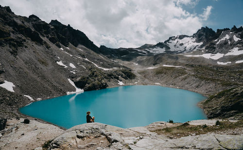 Scenic view of lake by mountains against sky