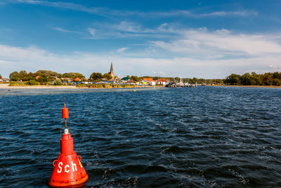 Sea by buildings against sky