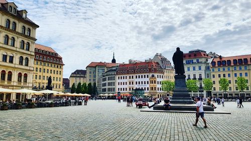 People walking on street amidst buildings in city