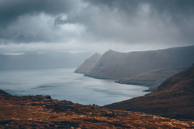 Scenic view of sea and mountains against sky