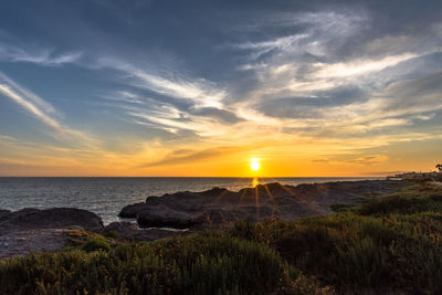 Sunset between the rocks and the sea in marsala trapani sicily italy