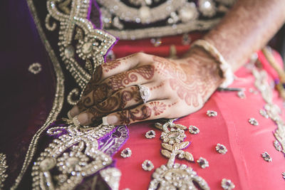 Midsection of bride with henna tattoo